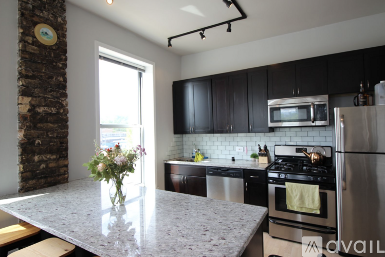 A kitchen with a stone column and a marble countertop.