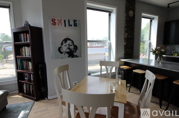 A dining room with a poster on the wall that says "SMILE".