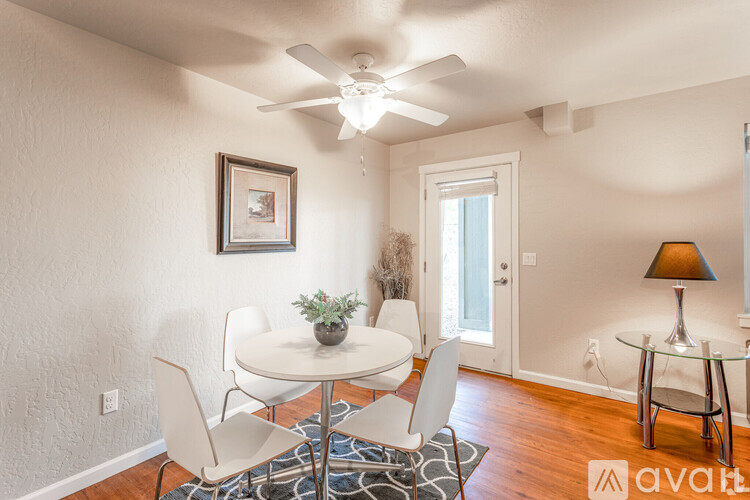 A dining room with a white table and chairs.