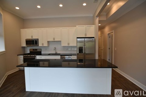 A kitchen with white cabinets and a black countertop.