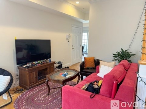 A living room with a red couch and a television.