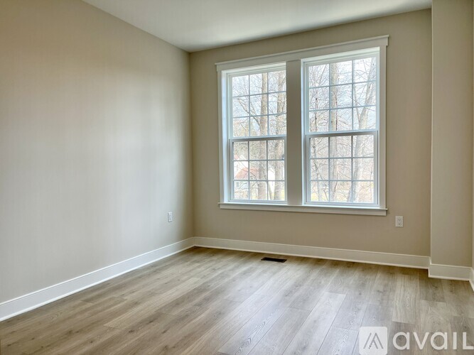 A room with a large window and wooden flooring is available for rent or purchase.