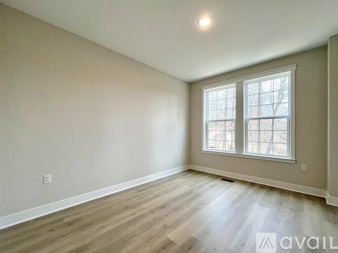 A room with a window and wooden flooring is available for rent or purchase.