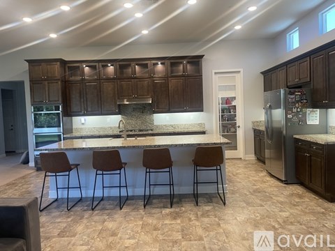 A kitchen with brown cabinets and a marble countertop.