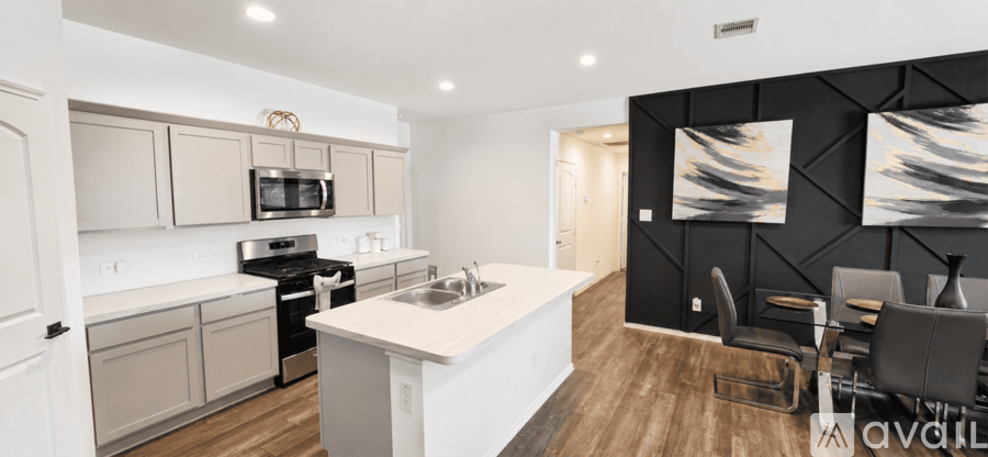 A modern kitchen with a white countertop and wooden flooring.