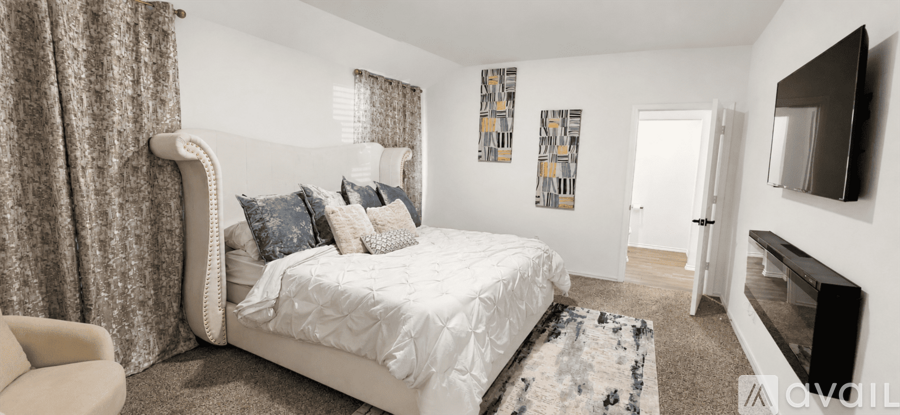 A bedroom with a large bed and a television.