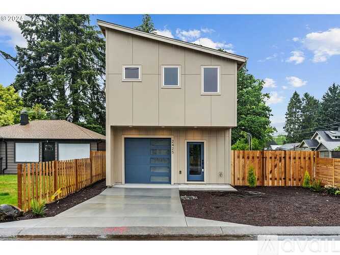 A modern house with a garage and a wooden fence.