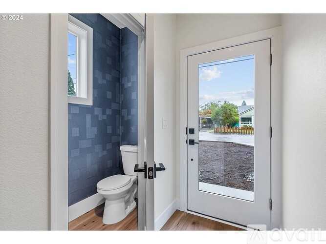 A bathroom with a toilet and a door leading outside.