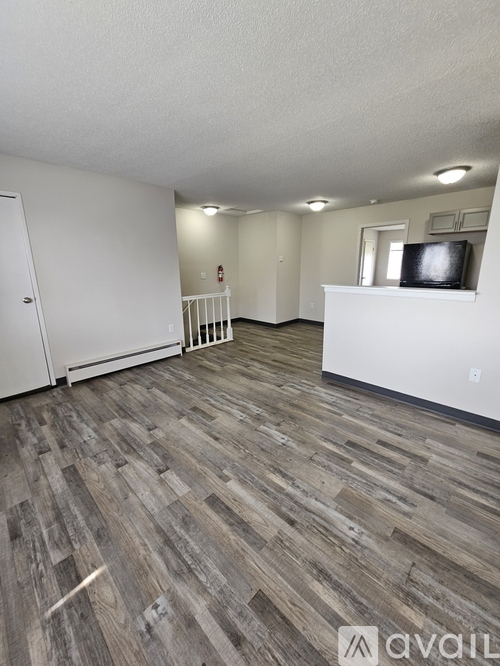 A room with wooden flooring and white walls.