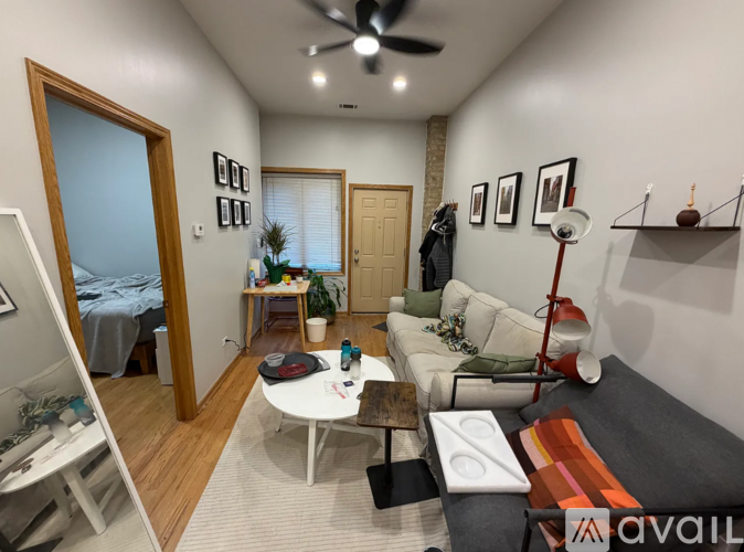 A living room with a white couch, a coffee table, and a ceiling fan.