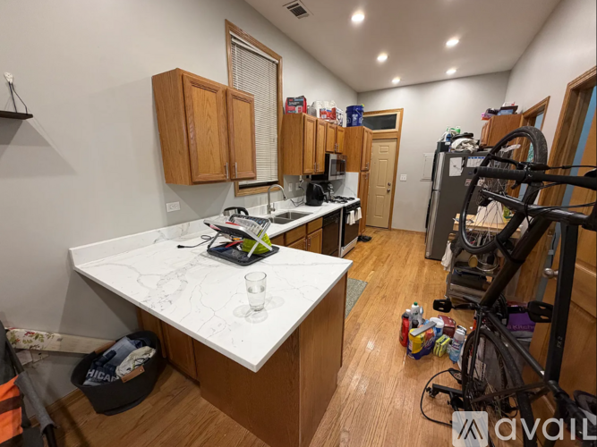 A kitchen with a white countertop and wooden cabinets.
