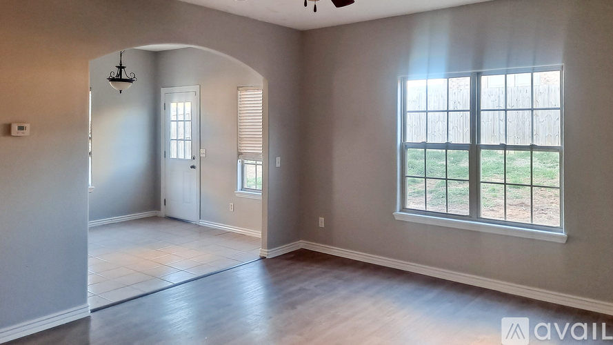 A room with a window overlooking a grassy area.
