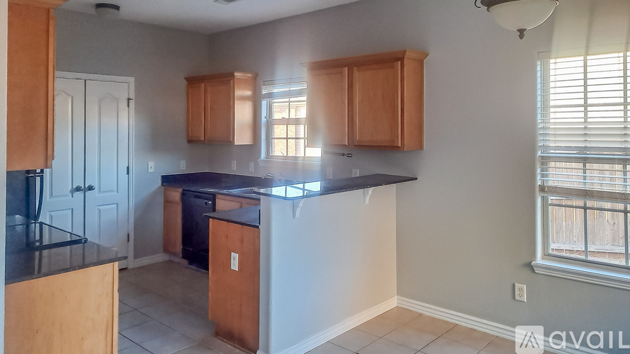 A kitchen with wooden cabinets and a black countertop.