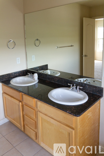 A bathroom with two sinks and a mirror.