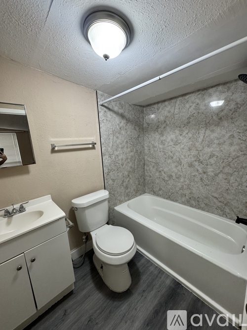 A bathroom with a toilet, sink, and bathtub.