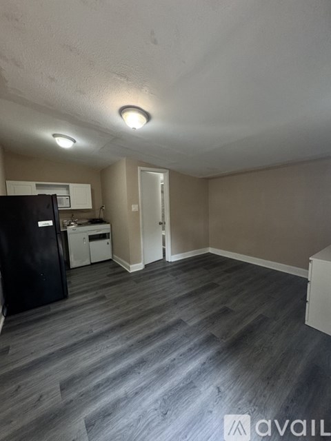 A kitchen area with a black fridge and a white dishwasher.