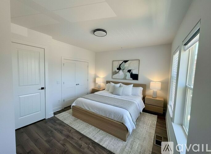 A bedroom with a large bed and a painting on the wall.