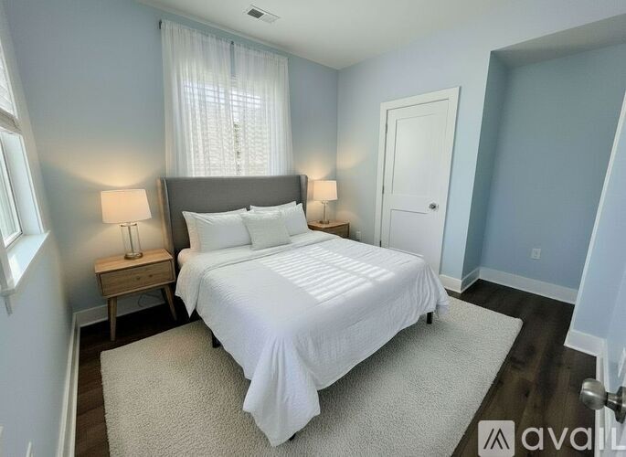 A bedroom with a large bed and two lamps.