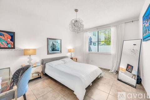A bedroom with a large bed, a chair, and a painting on the wall.