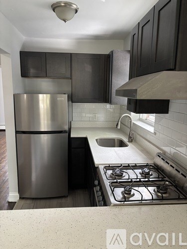 A kitchen with a stainless steel refrigerator and a stove top oven.