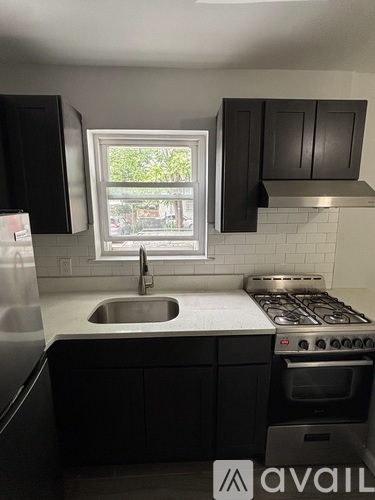 A kitchen with a window overlooking a street.