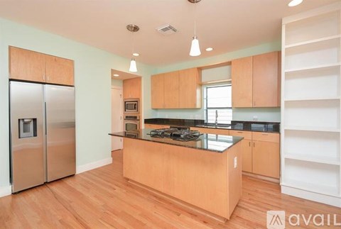 A kitchen with wooden cabinets and a stainless steel refrigerator.