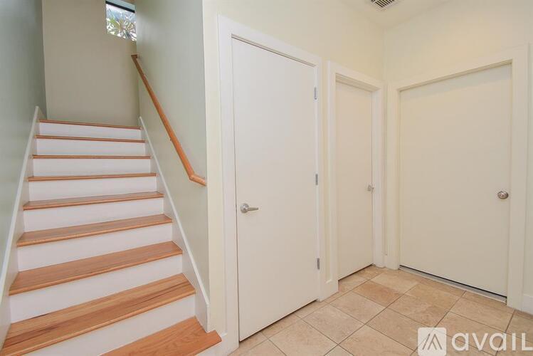 A hallway with a staircase on the left and two doors on the right.