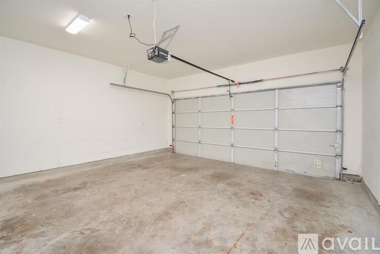 A garage with a white door and a fan on the ceiling.