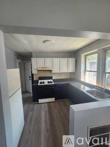 A kitchen with a white refrigerator and wooden floors.