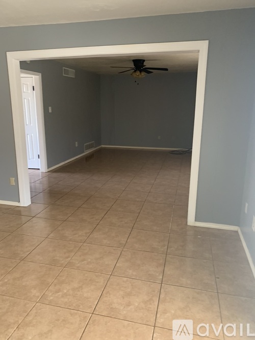 A room with a ceiling fan and tiled floor.