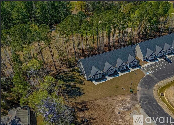 A bird's eye view of a parking lot with a building and trees.
