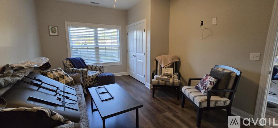 A living room with a couch, chair, and table.