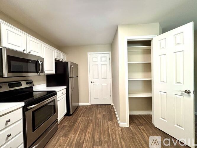 A kitchen with white cabinets and black appliances.