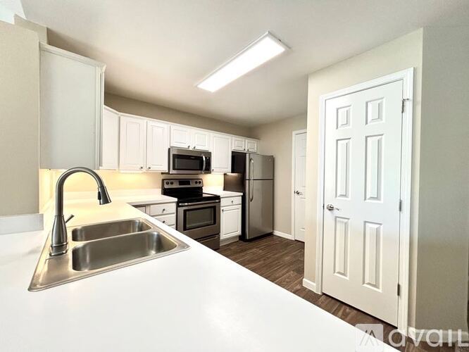 A kitchen with white cabinets and a white sink.