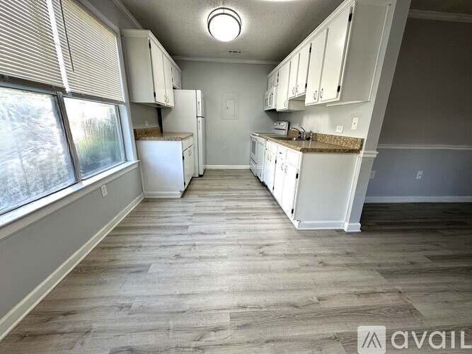 A kitchen with white appliances and cabinets is available for rent.