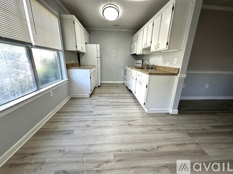 A kitchen with white appliances and cabinets is available for rent.