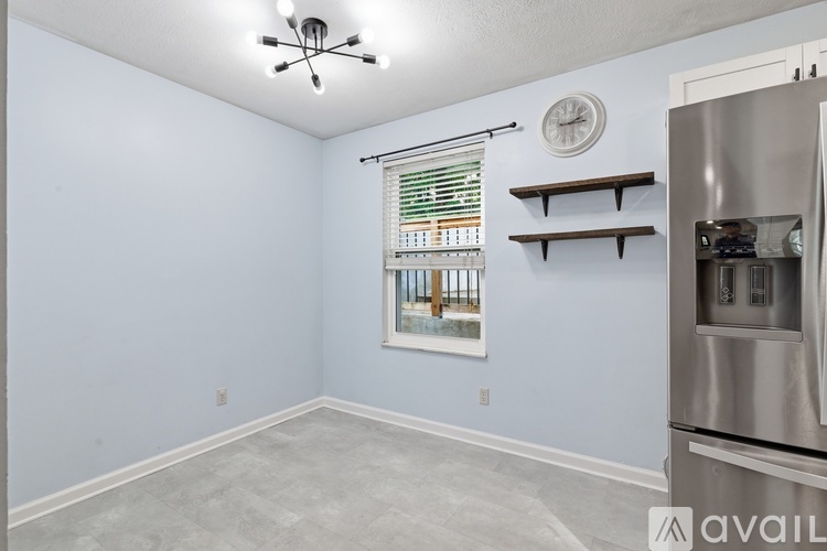 A kitchen area with a stainless steel refrigerator and a ceiling fan.