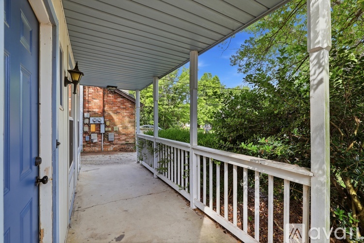 A porch with a blue door and white railings.
