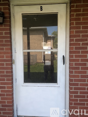 A white door with a black handle and a letter B above it.