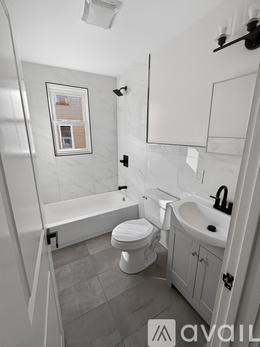 A bathroom with a toilet, sink, and bathtub.