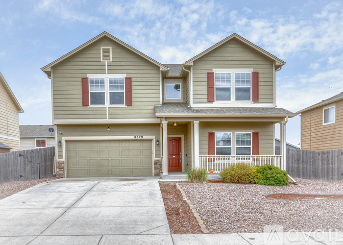 A two-story house with a garage and a driveway.