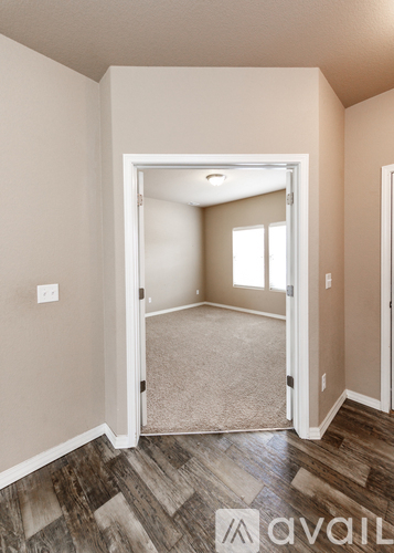 A room with a carpeted floor and a doorway leading to another room.