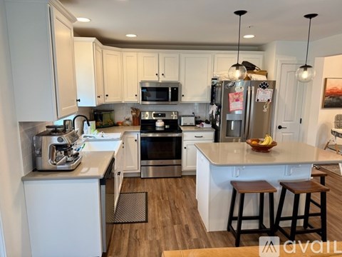 A kitchen with white cabinets and a refrigerator with magnets on it.