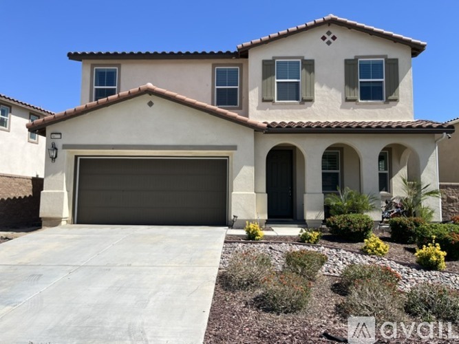 A two-story house with a garage and a driveway.
