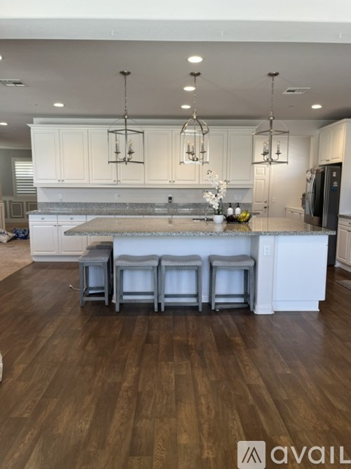 A kitchen with white cabinets and a wooden floor.