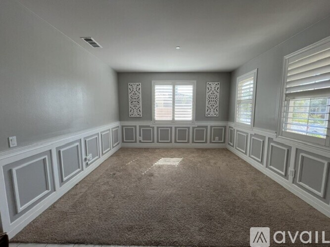 A spacious room with a carpeted floor and decorative panels on the walls.