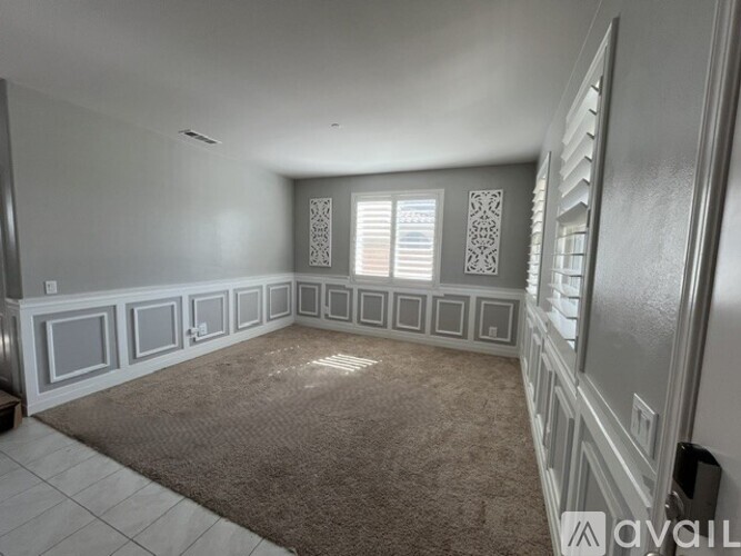 A spacious room with a carpeted floor and decorative wall panels.