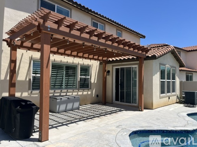 A house with a pool and a pergola.