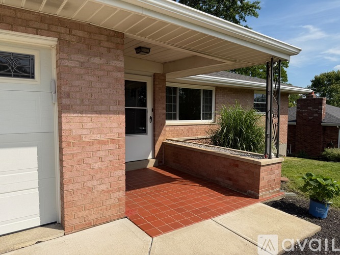 A house with a white garage door and a brick wall.