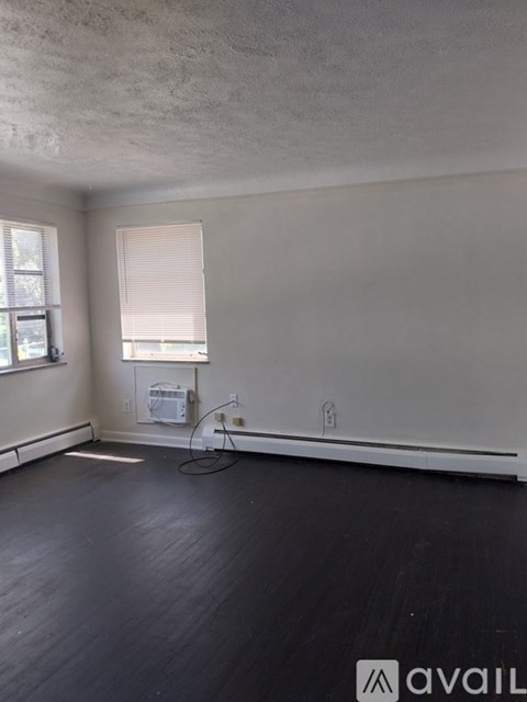 A room with a window and a fan on the floor.